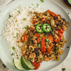 Instant Pot Picadillo over rice with lime wedges.