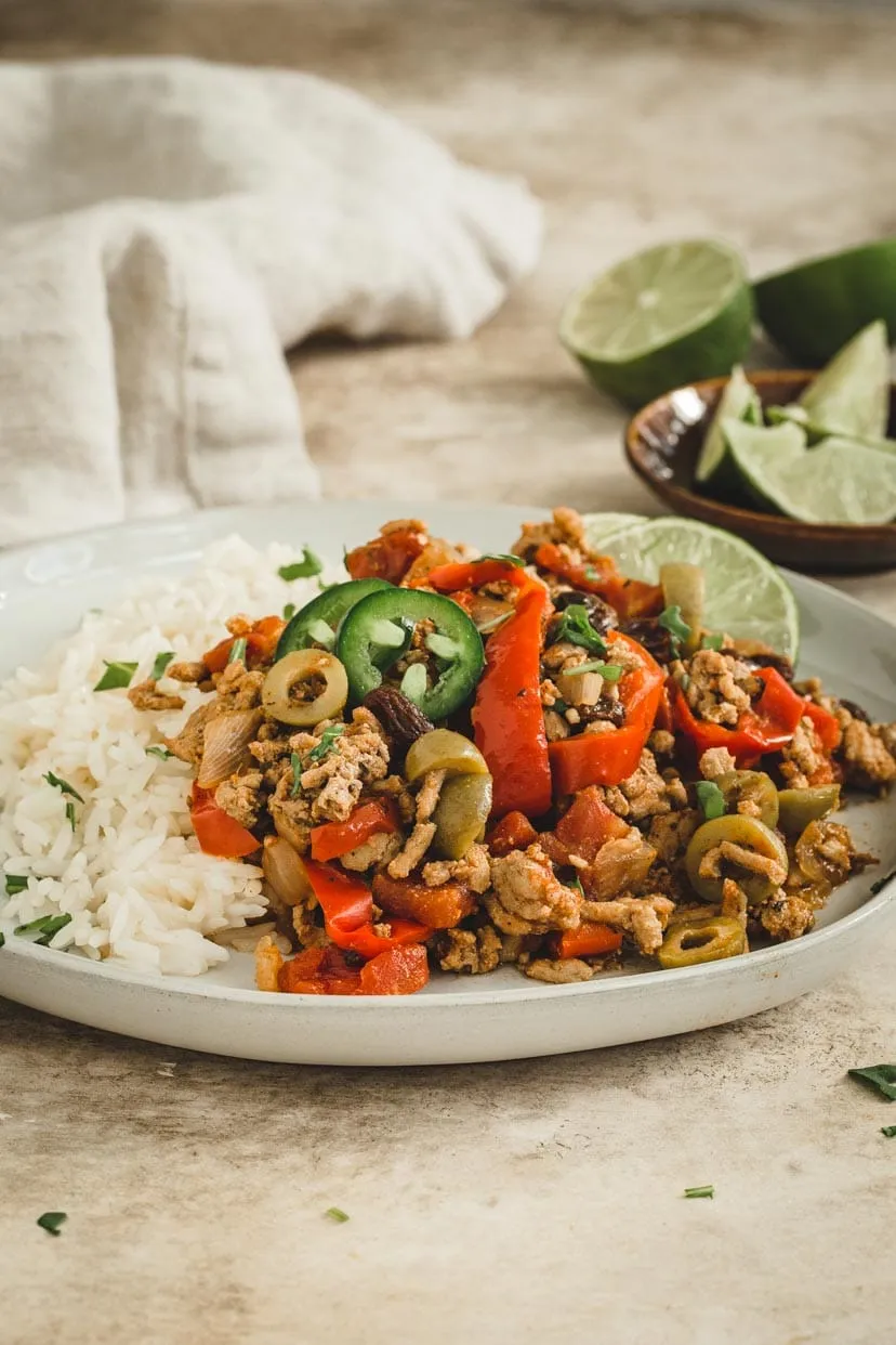 Instant Pot Picadillo over rice on a white plate.