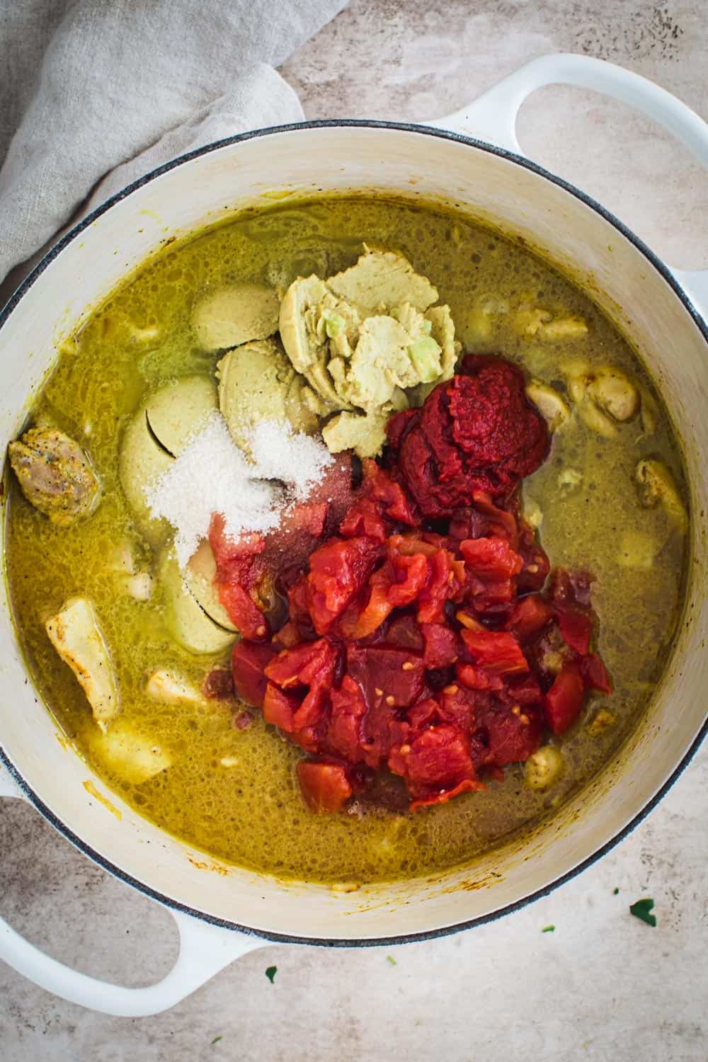 Coconut chicken curry ingredients in a white Dutch Oven.