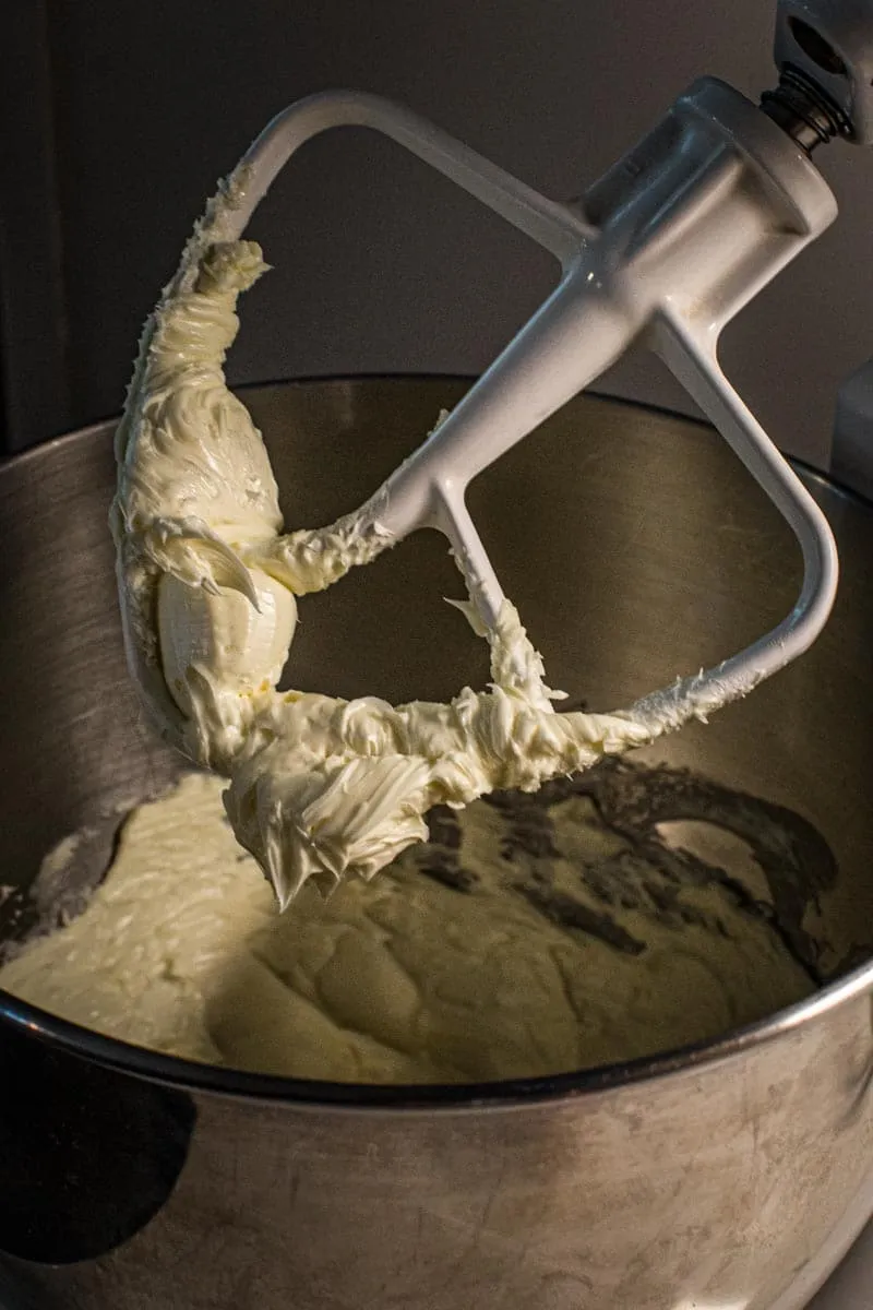 Paddle attachment of an electric mixer coated in beaten butter.