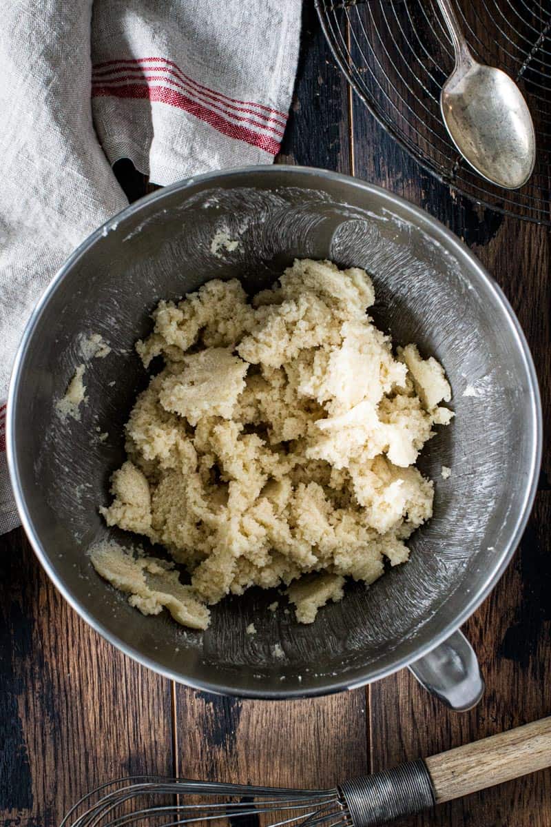 Creamed butter and sugar in silver mixing bowl.