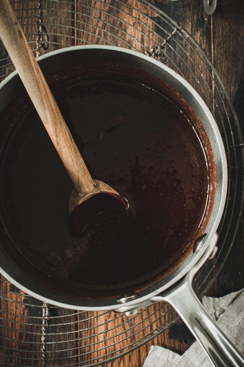 Melted chocolate in a medium silver pot.