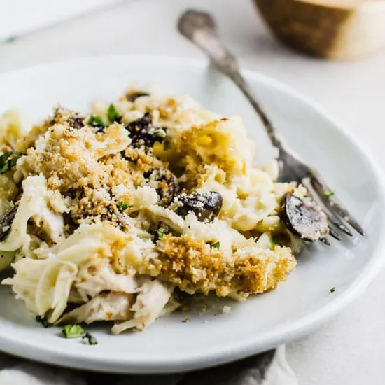 Chicken tetrazzini casserole on a white plate with a silver fork.