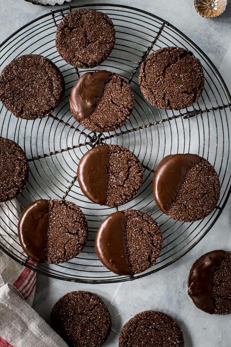 Chocolate-dipped soft ginger cookies on a round wire rack.