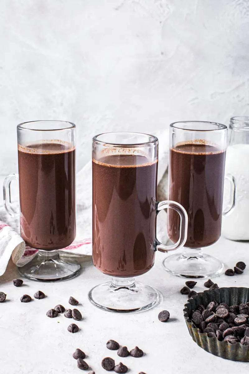 Three hot chocolates in tall glasses with slim handle.