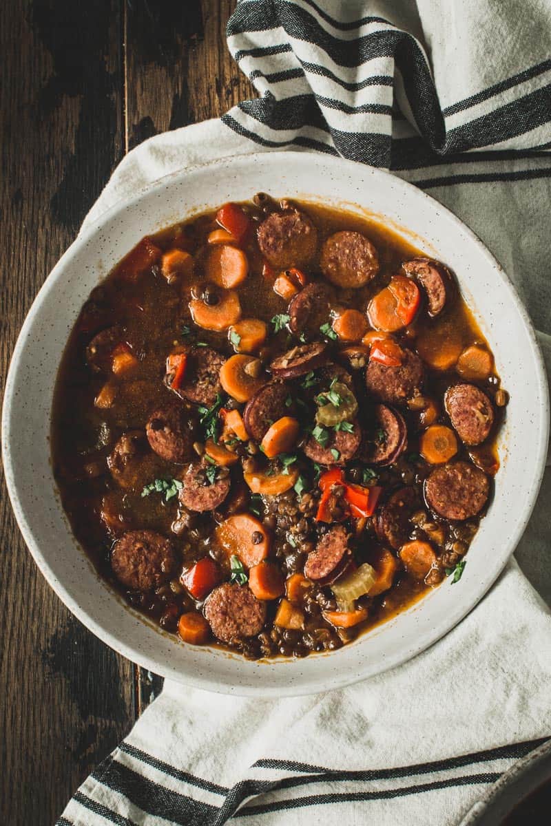 Instant pot sausage and lentil stew in a white bowl.