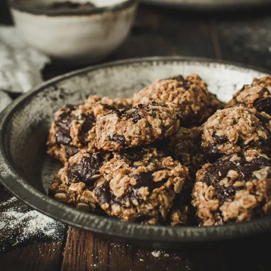 Vegan chocolate chip oatmeal cookies in a metal pie tin.