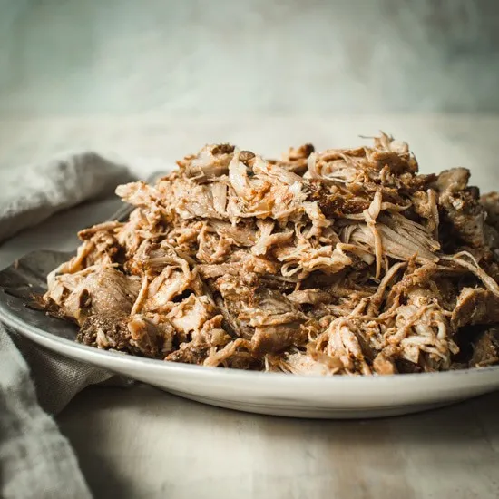 Pulled pork sitting on a white bowl.