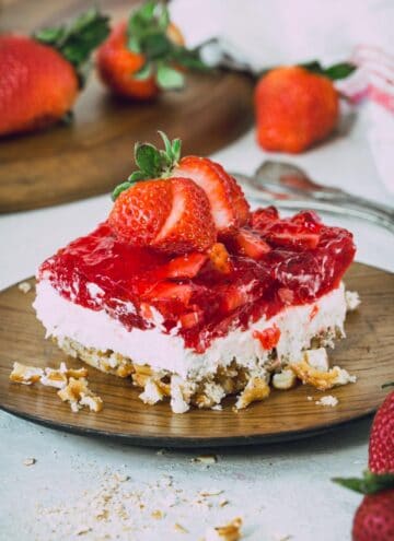 Gluten-free strawberry pretzel salad topped with a sliced strawberry.