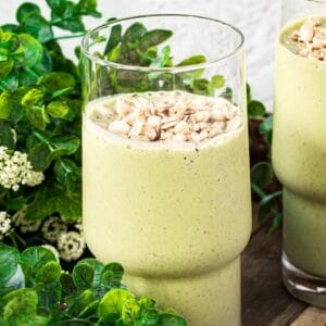 Simple green smoothie in a glass topped with granola.