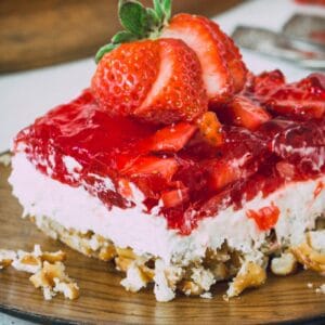 Gluten-free strawberry pretzel salad on a wooden plate.