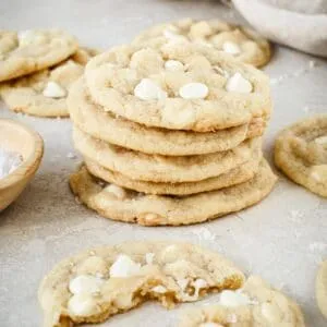 Salted white chocolate chip cookies stacked on top of each other.