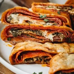Stromboli slices stacked on a white plate.