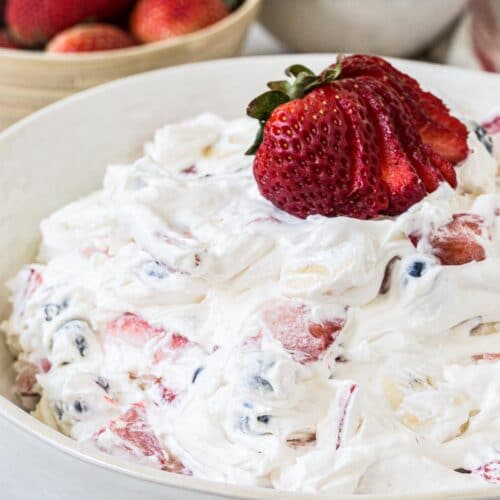 Mixed berry cheesecake salad in a white bowl.