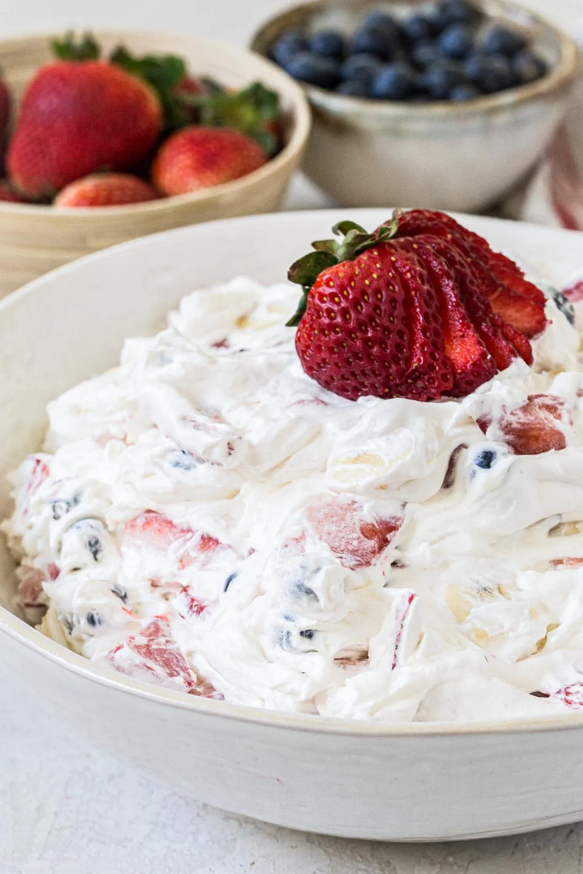 Mixed berry cheesecake salad in a white bowl.