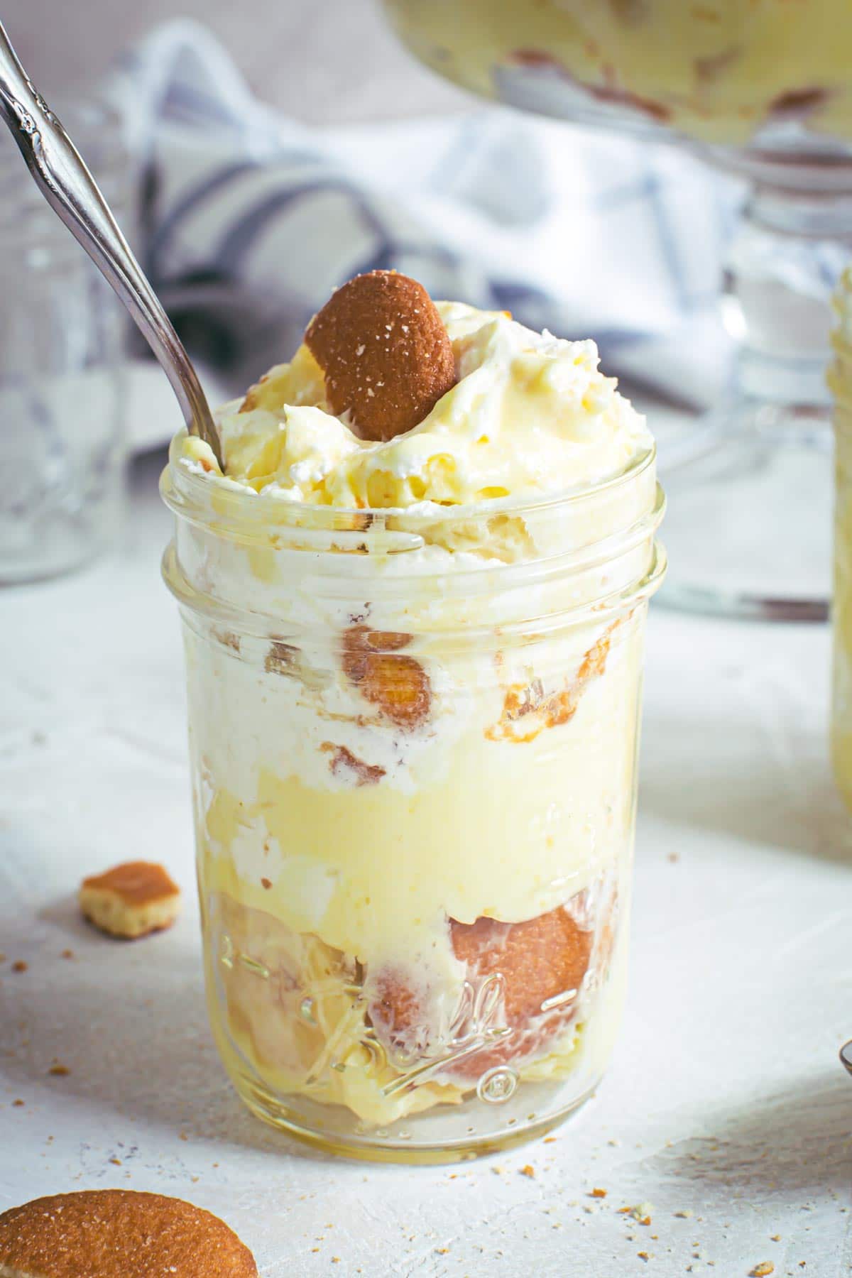 Best banana pudding layered in a mason jar with a spoon.