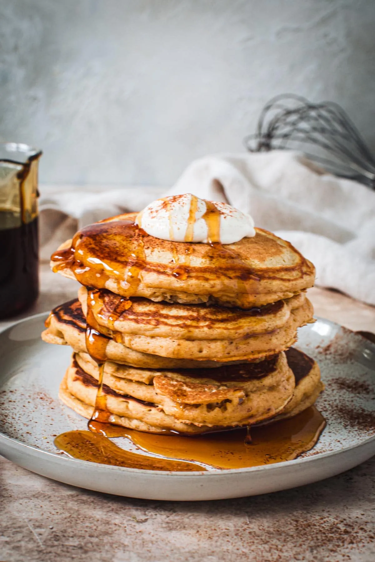 Sweet potato pancakes topped with cinnamon, whipped cream, and drizzled in syrup.