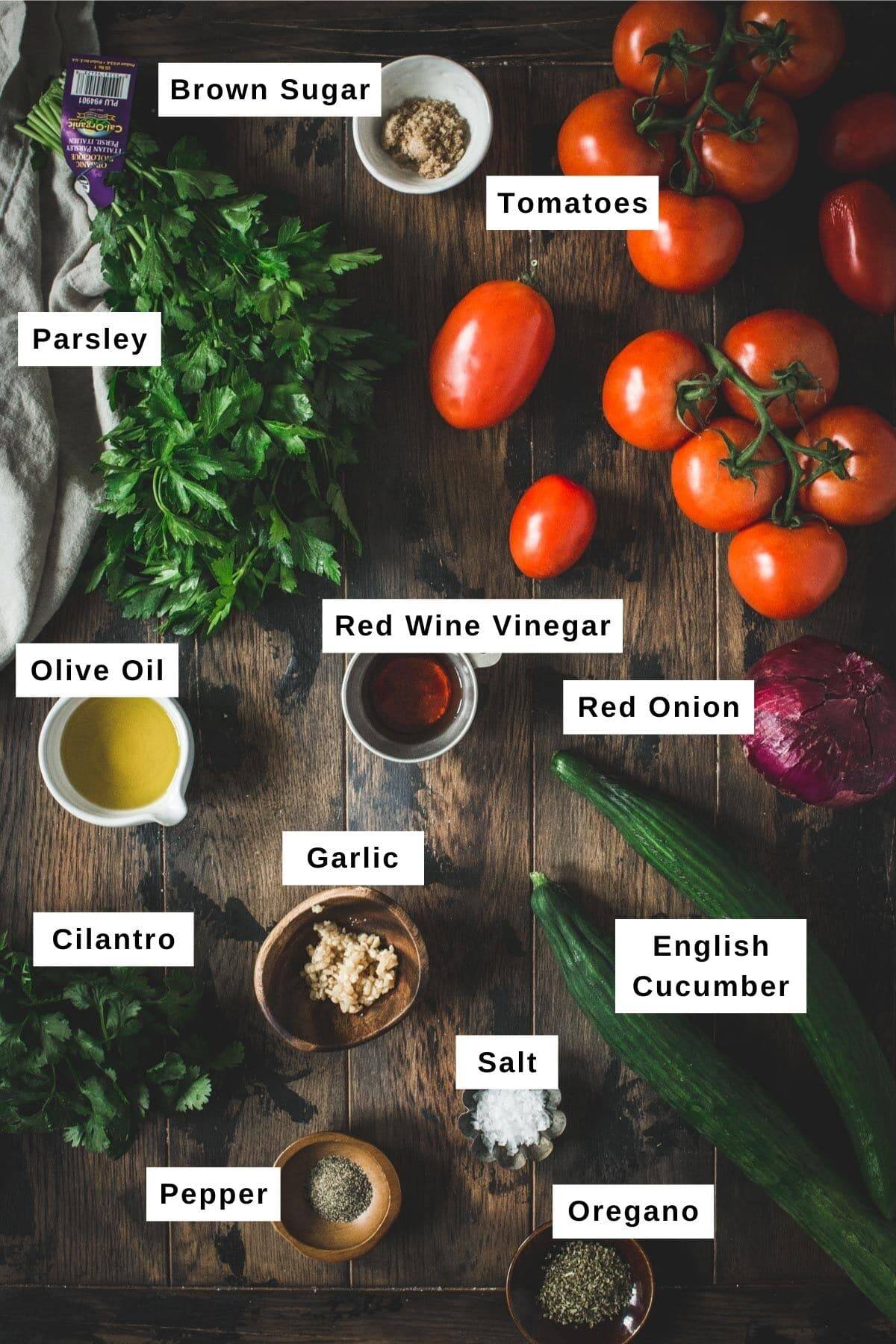 Cucumber, onion, and tomato salad ingredients on a wooden table.