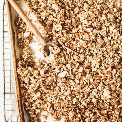 Honey vanilla granola recipe on a rimmed baking sheet.