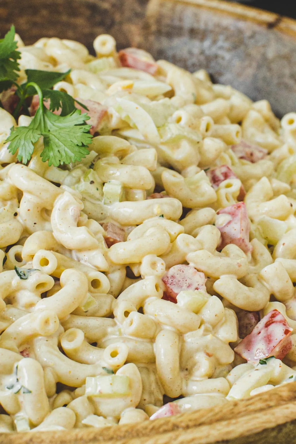 Close-up of macaroni salad in a wooden bowl.