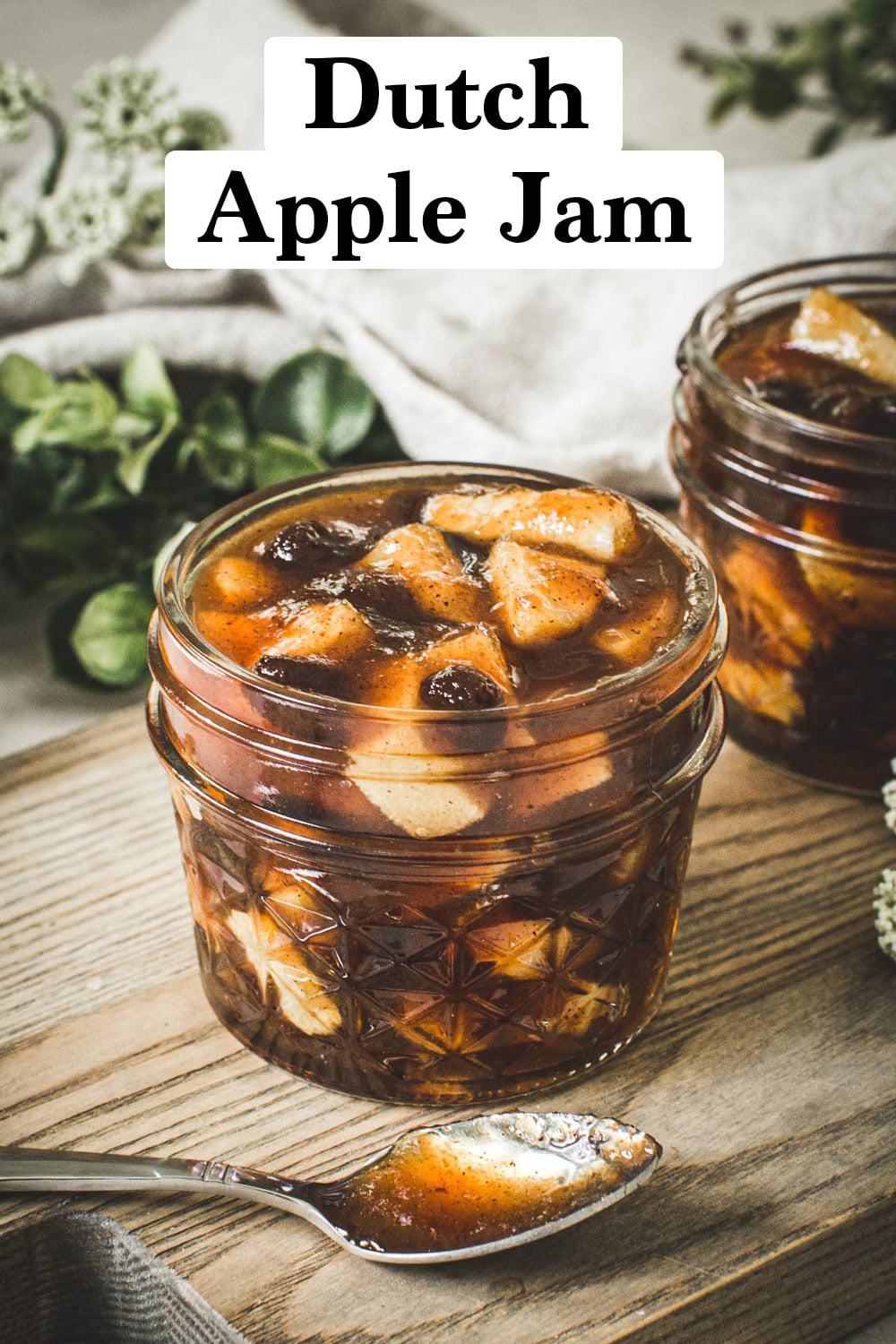 Dutch apple jam in a quarter-pint jar on a wooden cutting board.