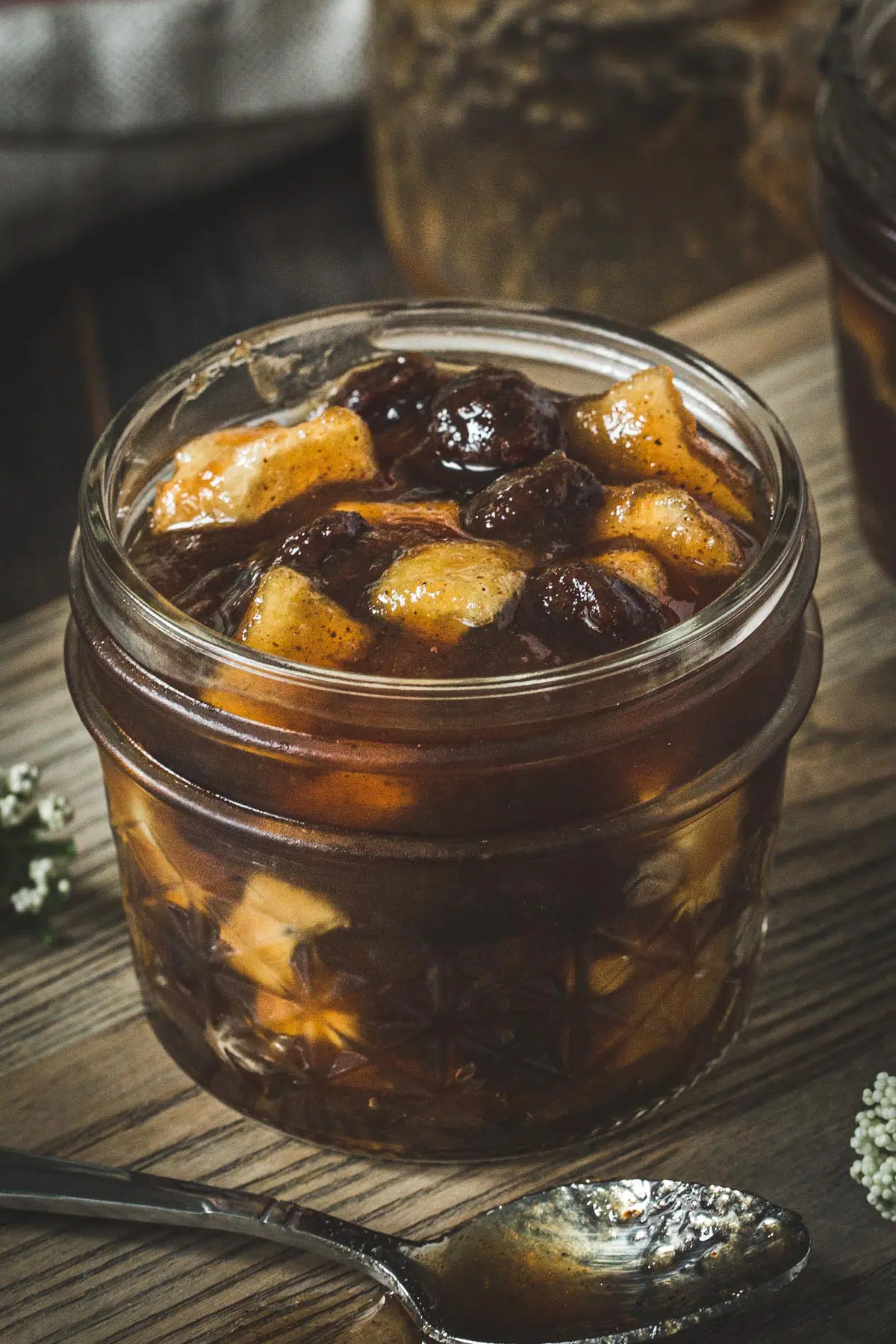 Apple jam with raisins and real chunks of apple in a glass jar.