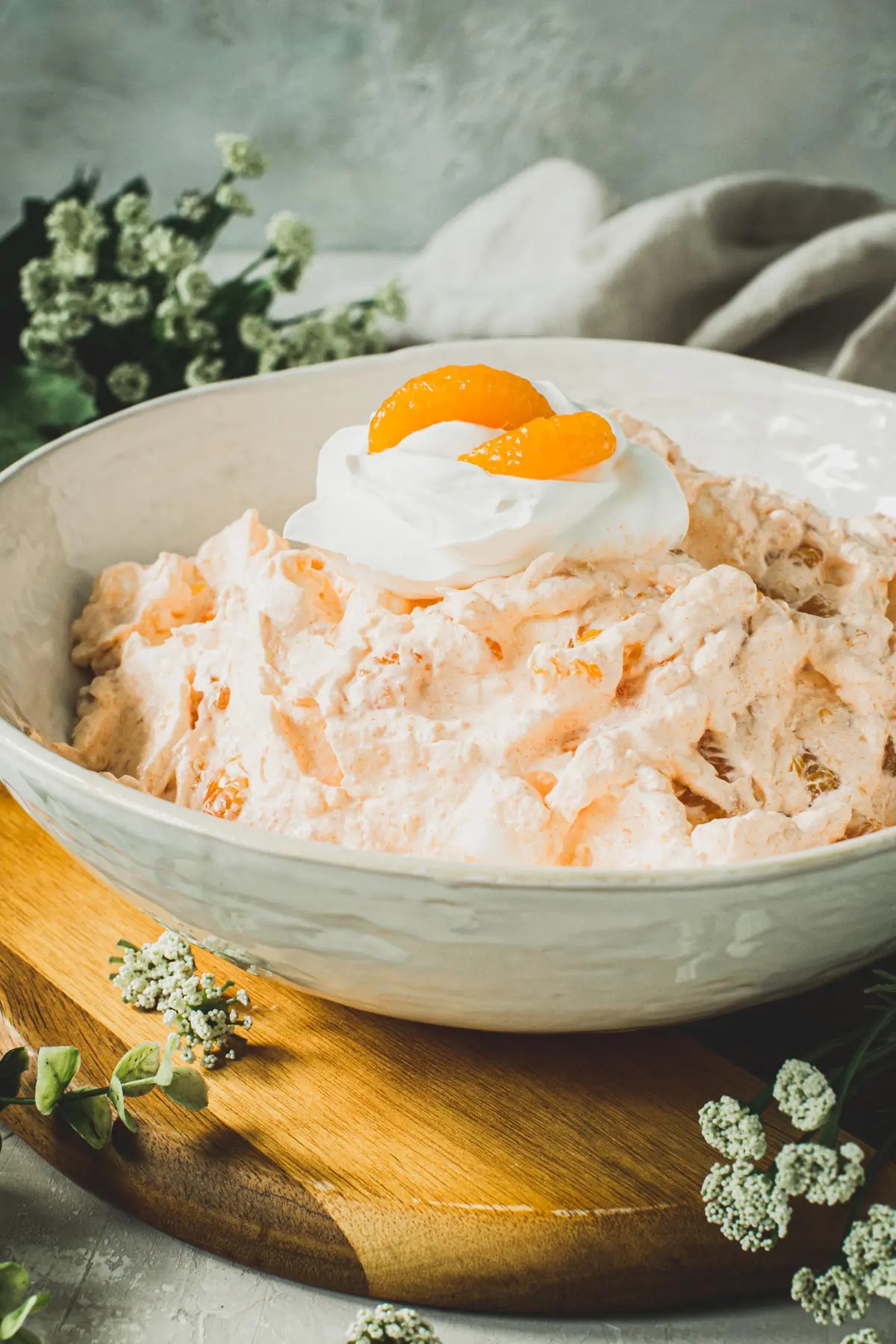 Mandarin orange jello salad in a white bowl.