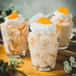 Personal mandarin orange jello salads in glass jars.