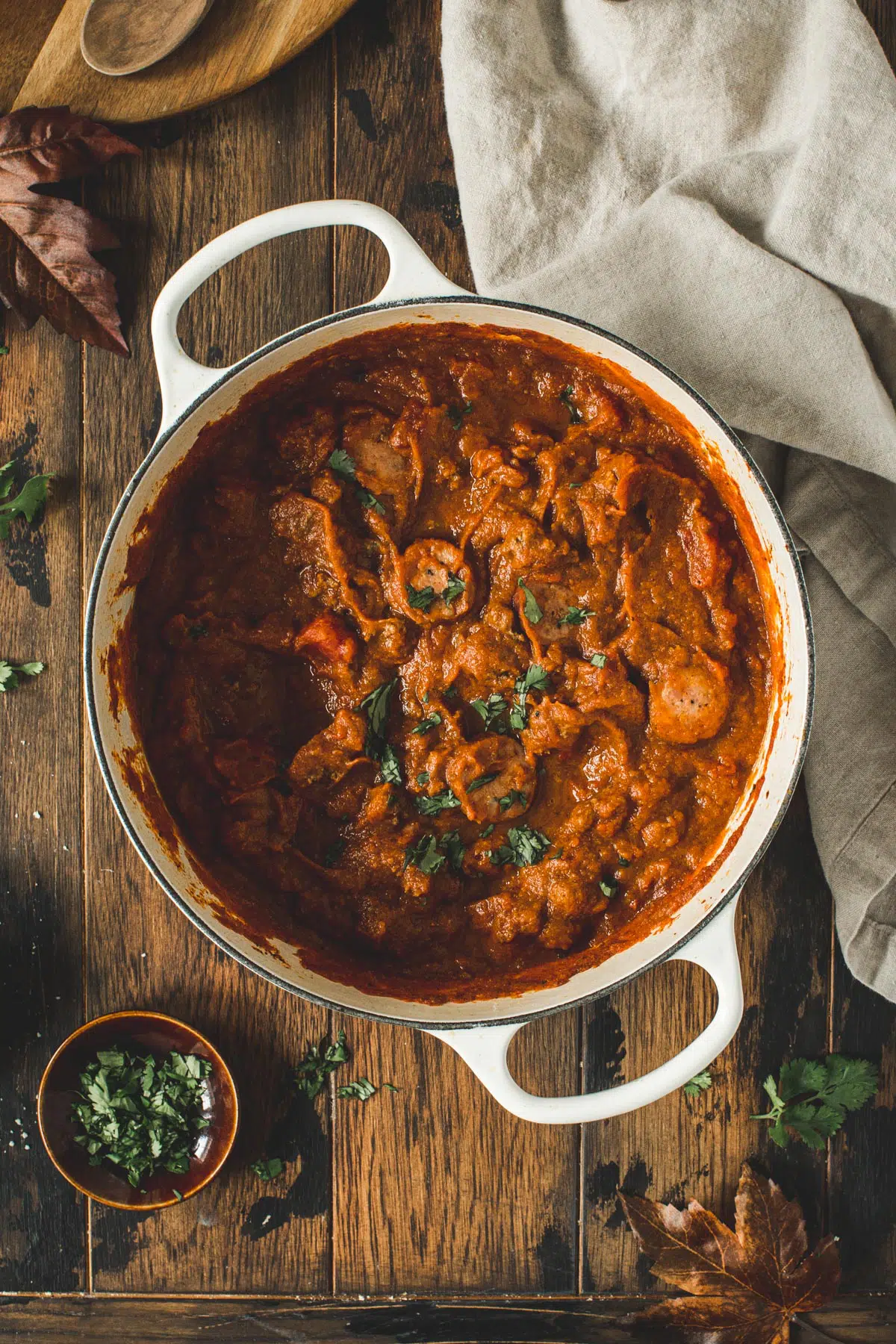 Pumpkin chili topped with fresh cilantro in a large white Dutch oven.