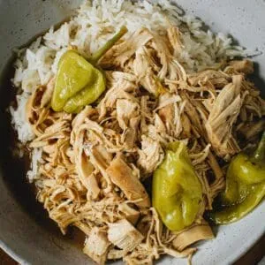 Mississippi chicken over rice in a pottery bowl.