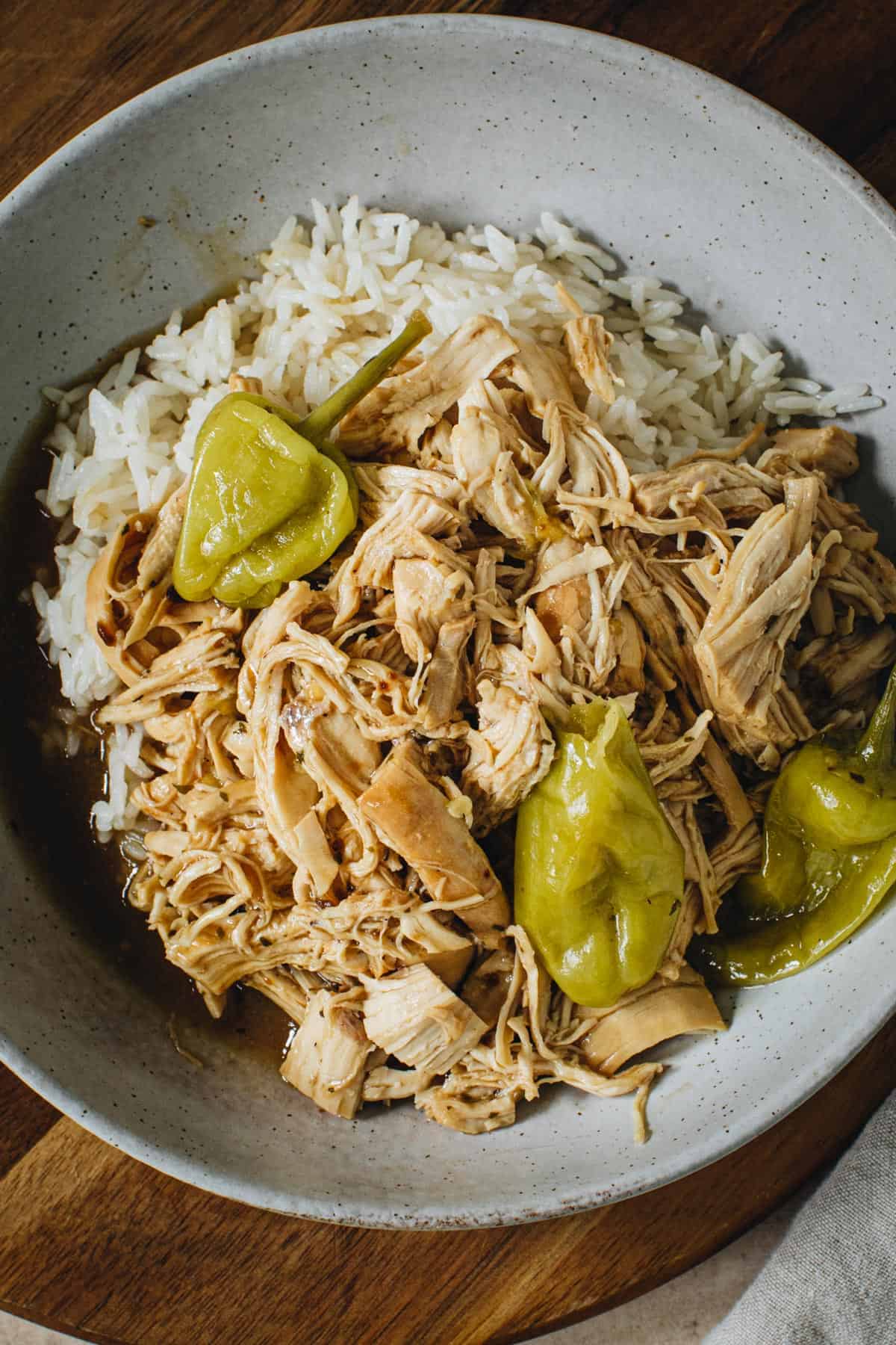 Mississippi chicken over rice in a pottery bowl.