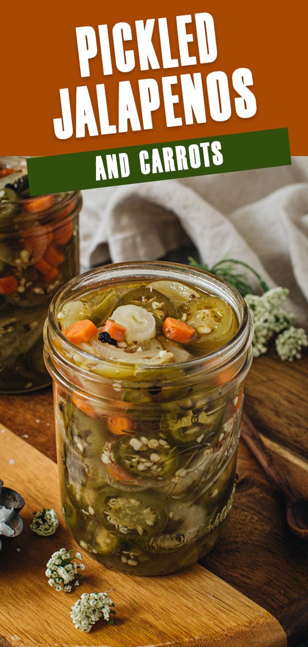 Pickled jalapenos and carrots in a wide mouth glass jar.
