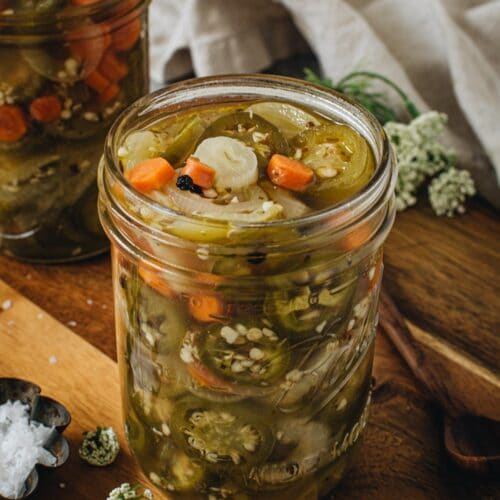 Pickled jalapenos and carrots in a large mason jar.