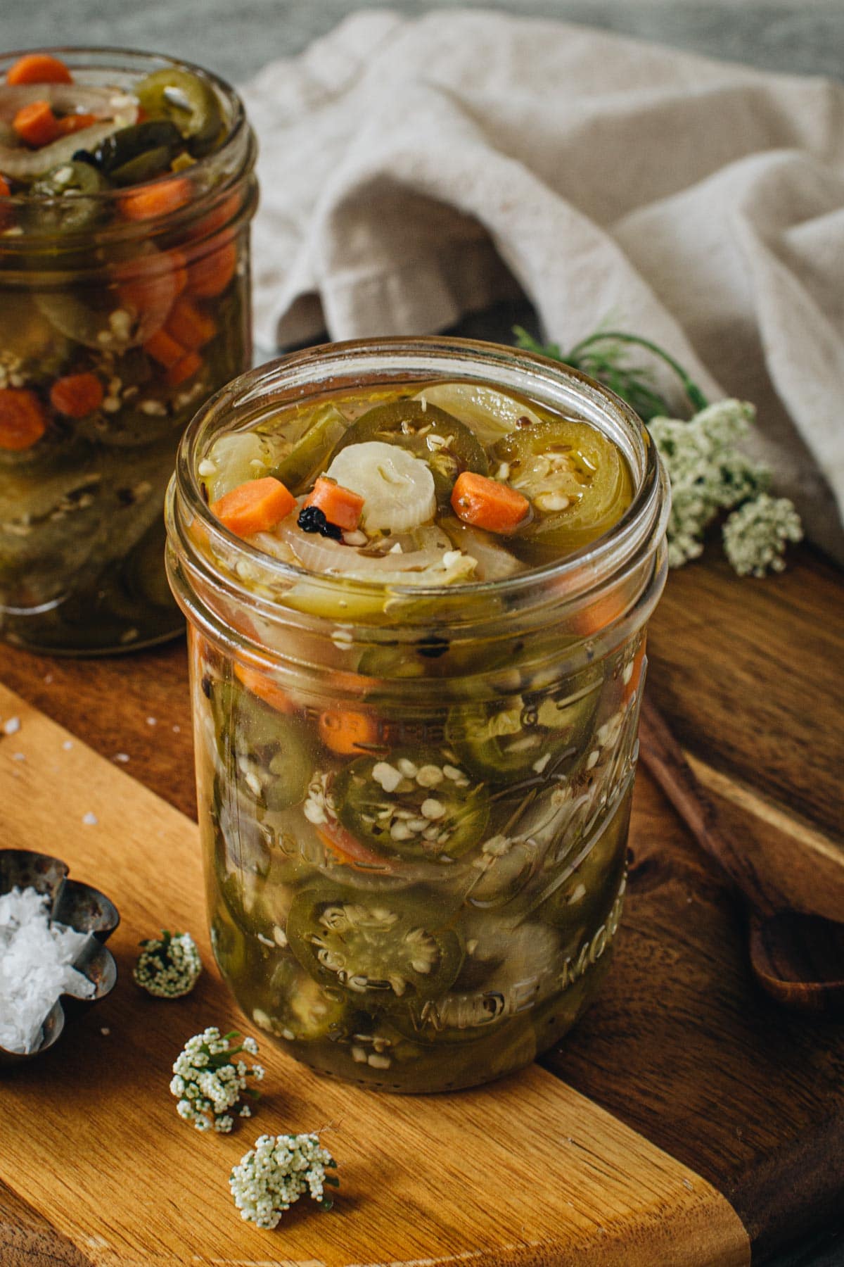 Pickled jalapenos and carrots in a large mason jar.