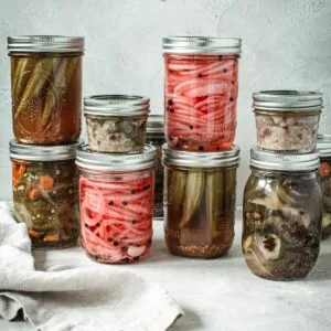 Cans of quick pickled vegetables in jars stacked on top of each other.