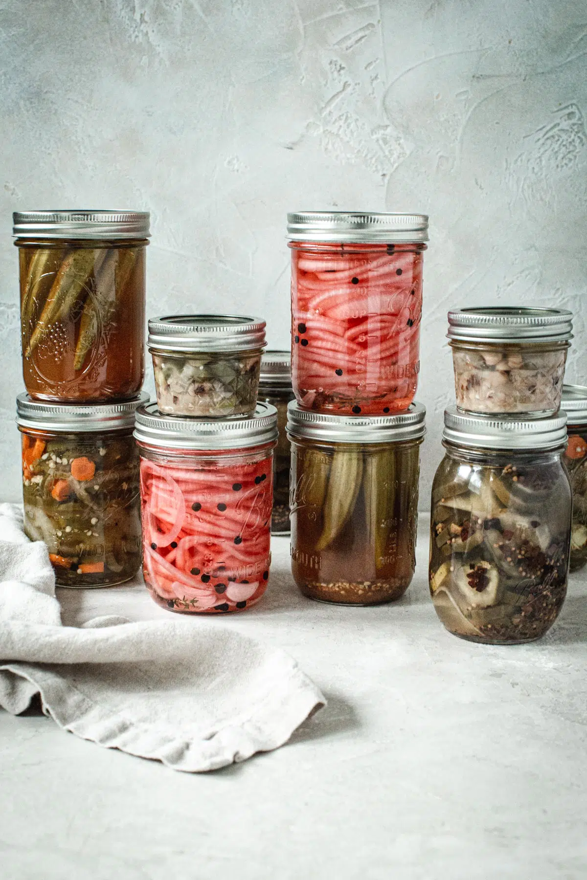 Cans of quick pickled vegetables in jars stacked on top of each other.