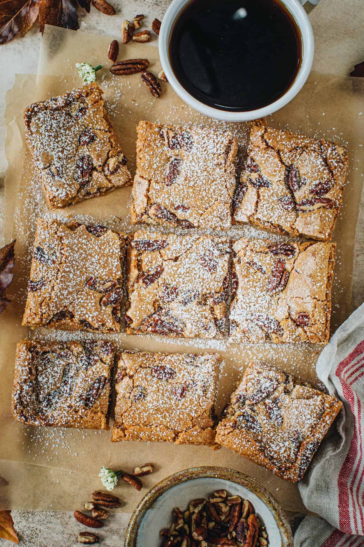 Charleston Chewies coated in powdered sugar sitting on parchment paper.