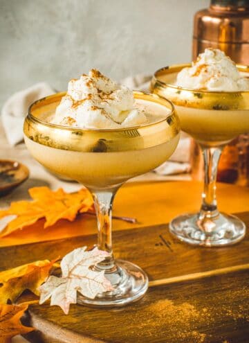Pumpkin martini topped with whipped cream and cinnamon in a martini glass.