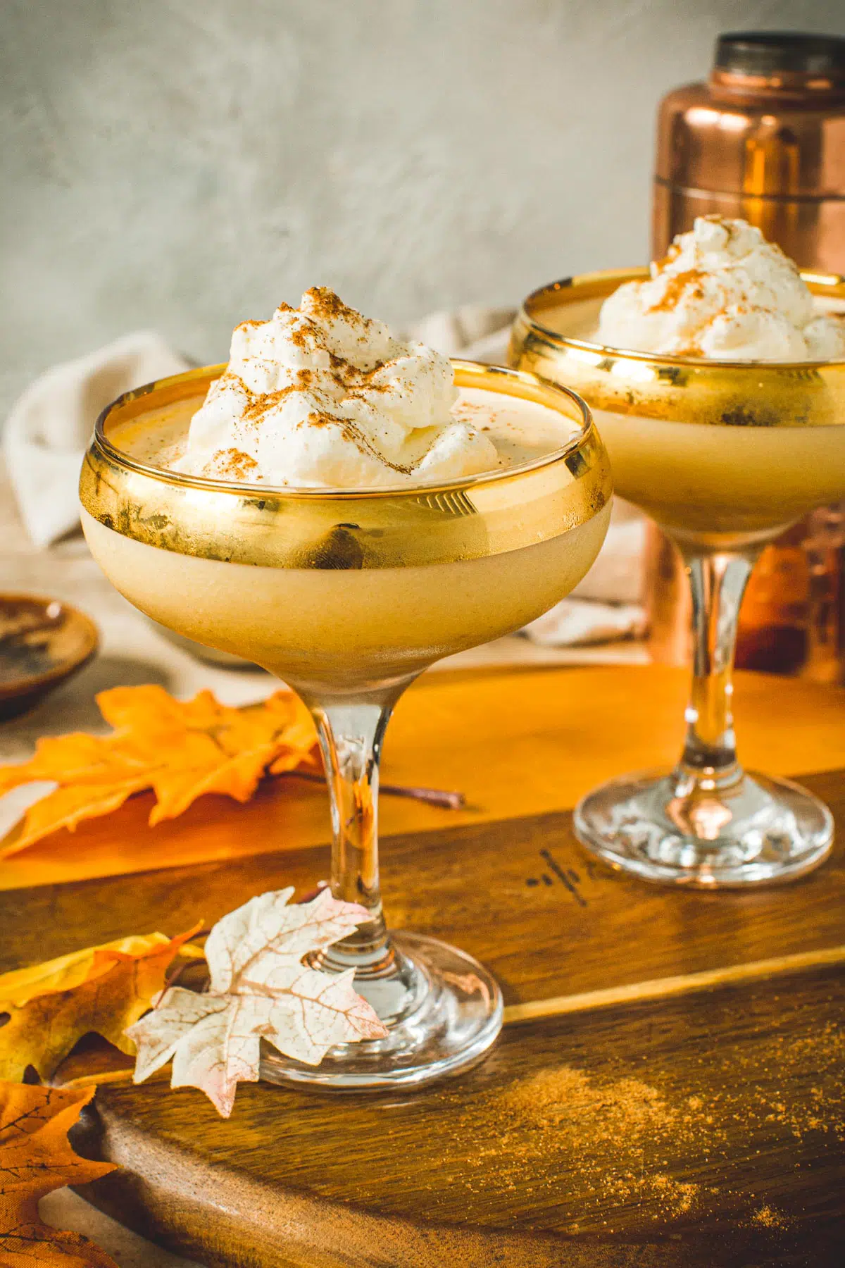 Pumpkin martini topped with whipped cream and cinnamon in a martini glass.