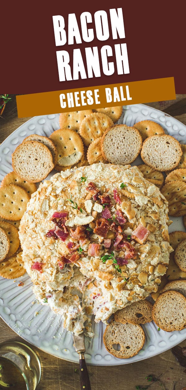 Bacon ranch cheese ball topped with bacon crumbles on a white plate.