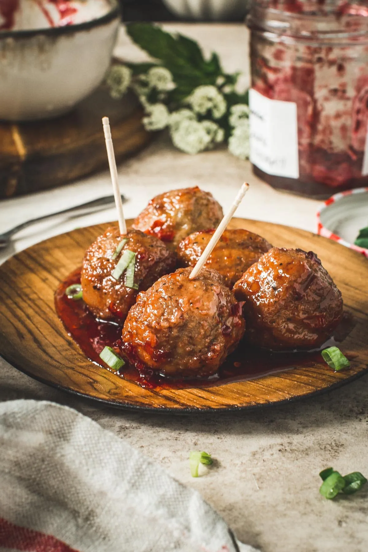 Party meatballs on a plate with toothpick in them.