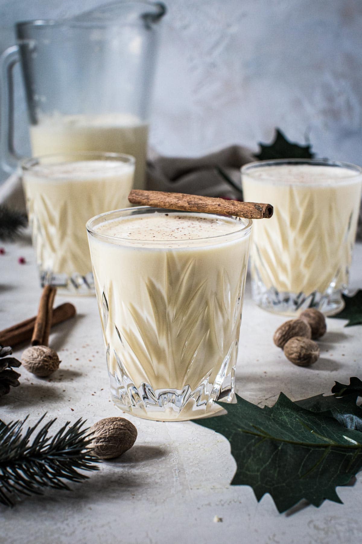 Eggnog in glasses with a cinnamon stick on top.