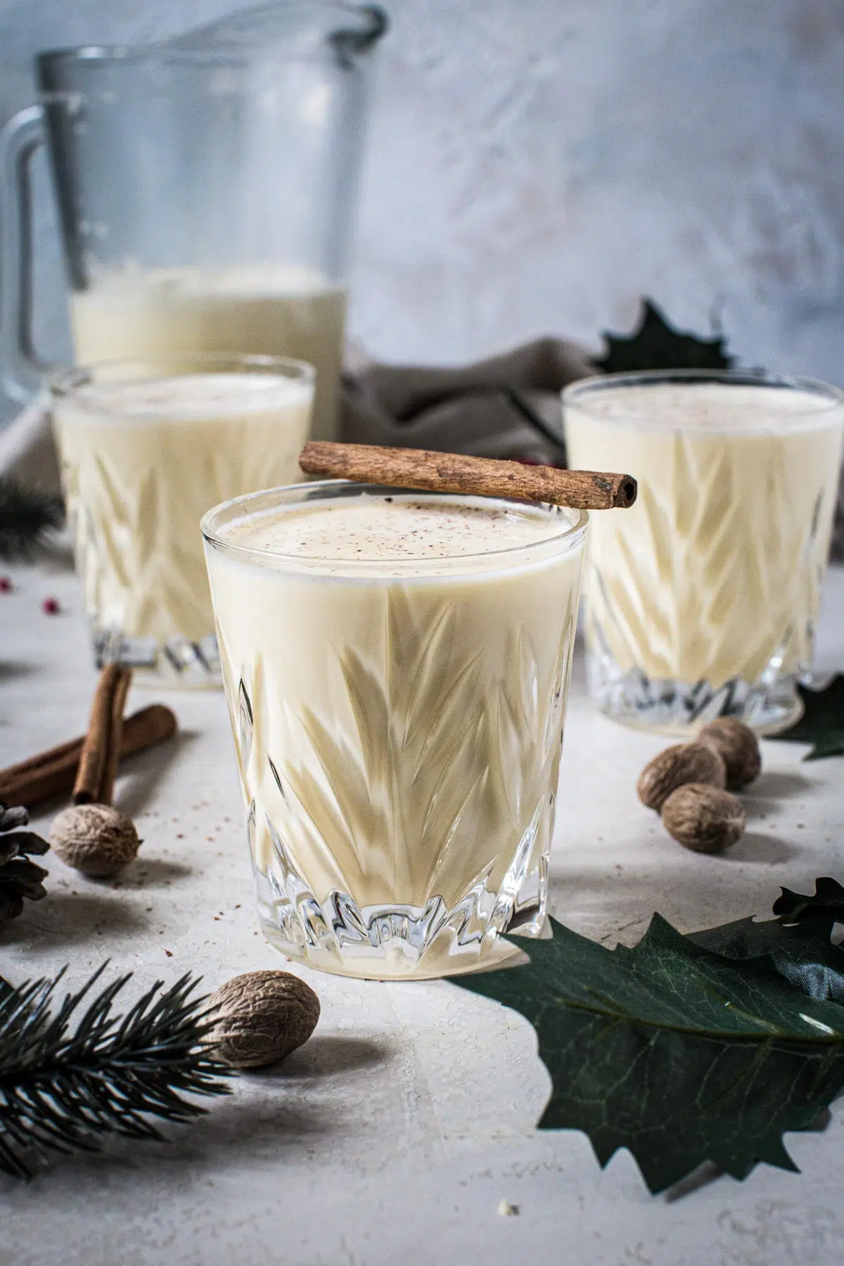 Eggnog in glasses with a cinnamon stick on top.