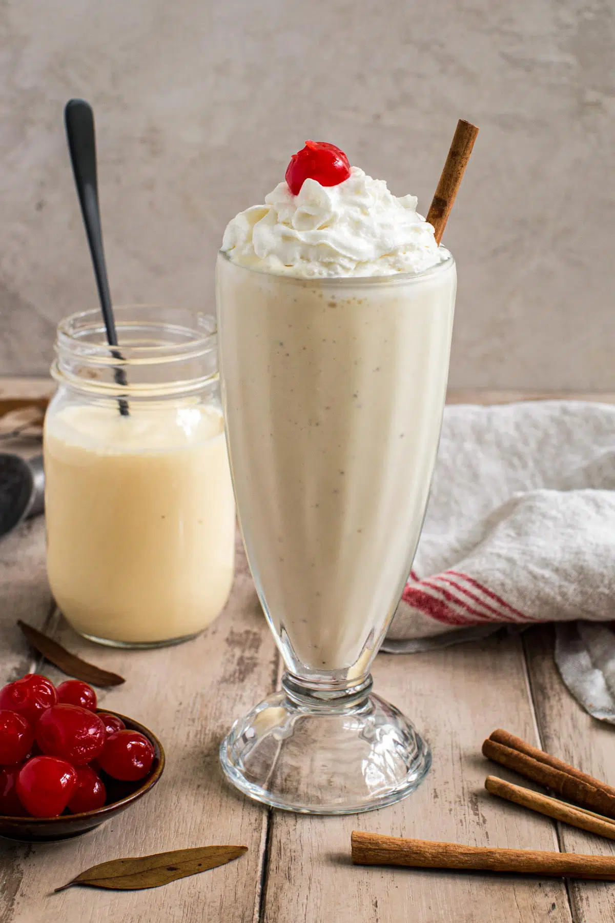Eggnog milkshake topped with whipped cream and a cherry.
