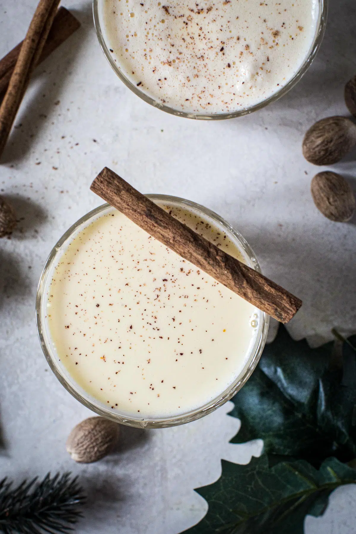 Eggnog topped with cinnamon stick and nutmeg.