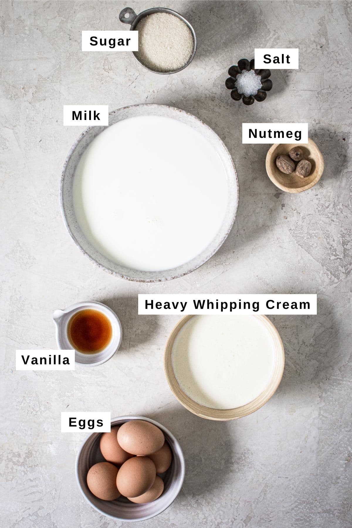 Homemade eggnog ingredients in various bowls.