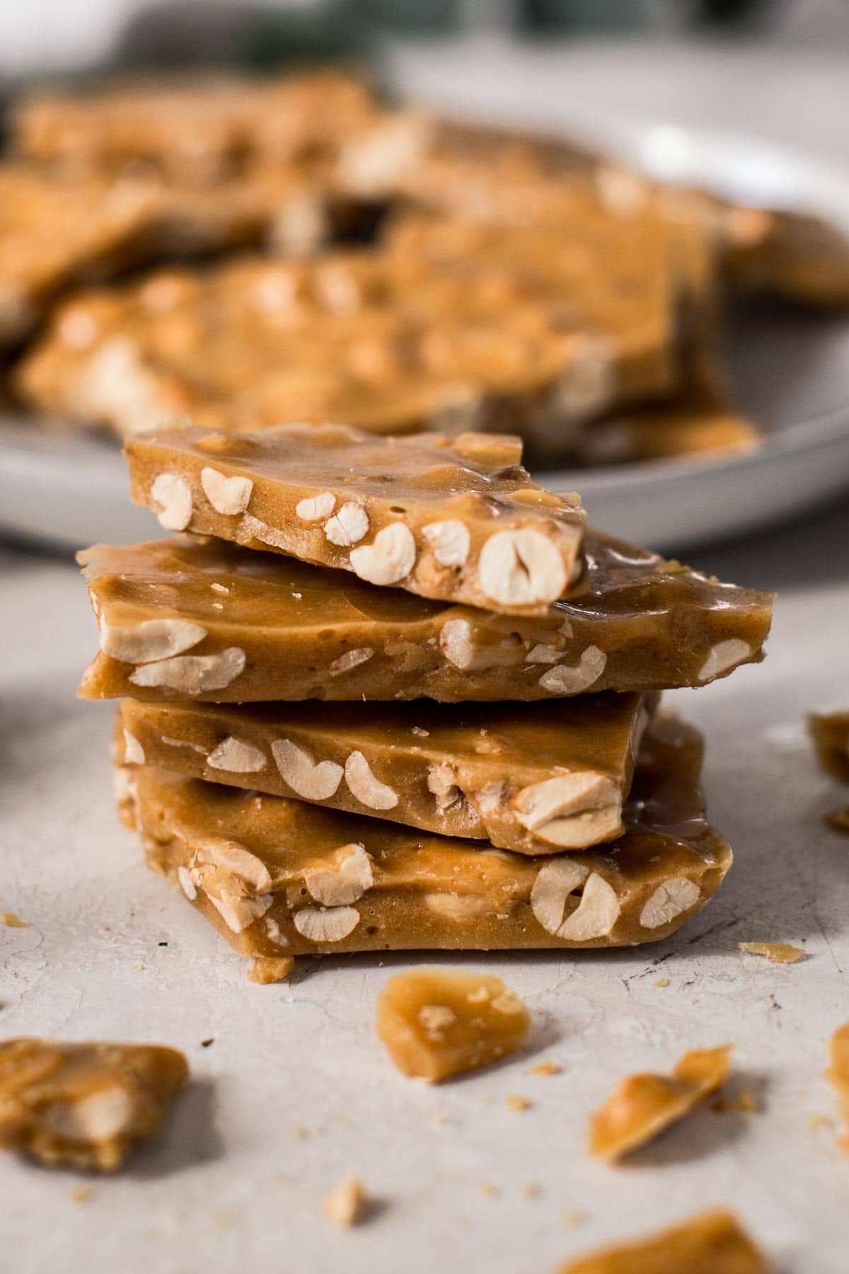 Stack of microwave peanut brittle with crumbles surrounding it.