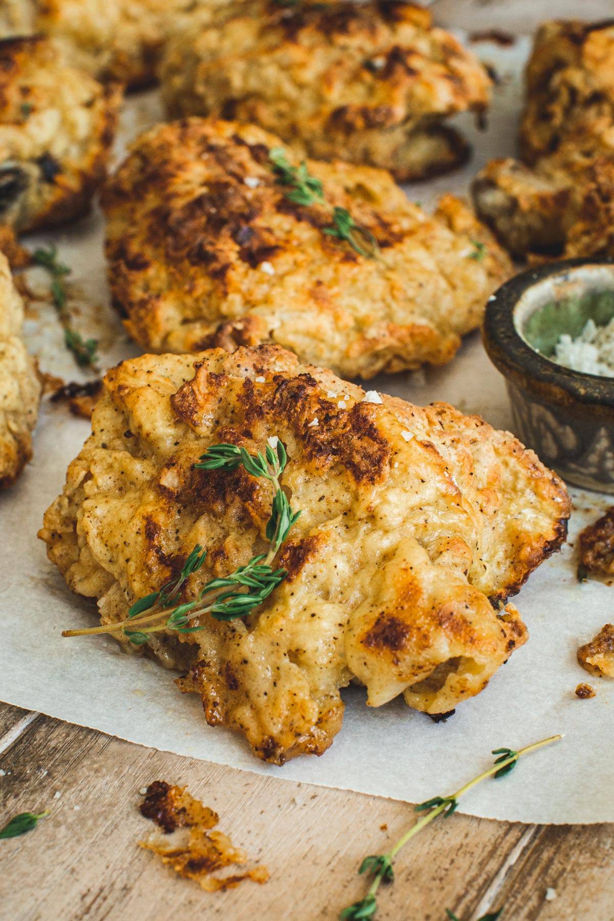 Baked fried chicken thigh with fresh thyme and coarse salt on top.