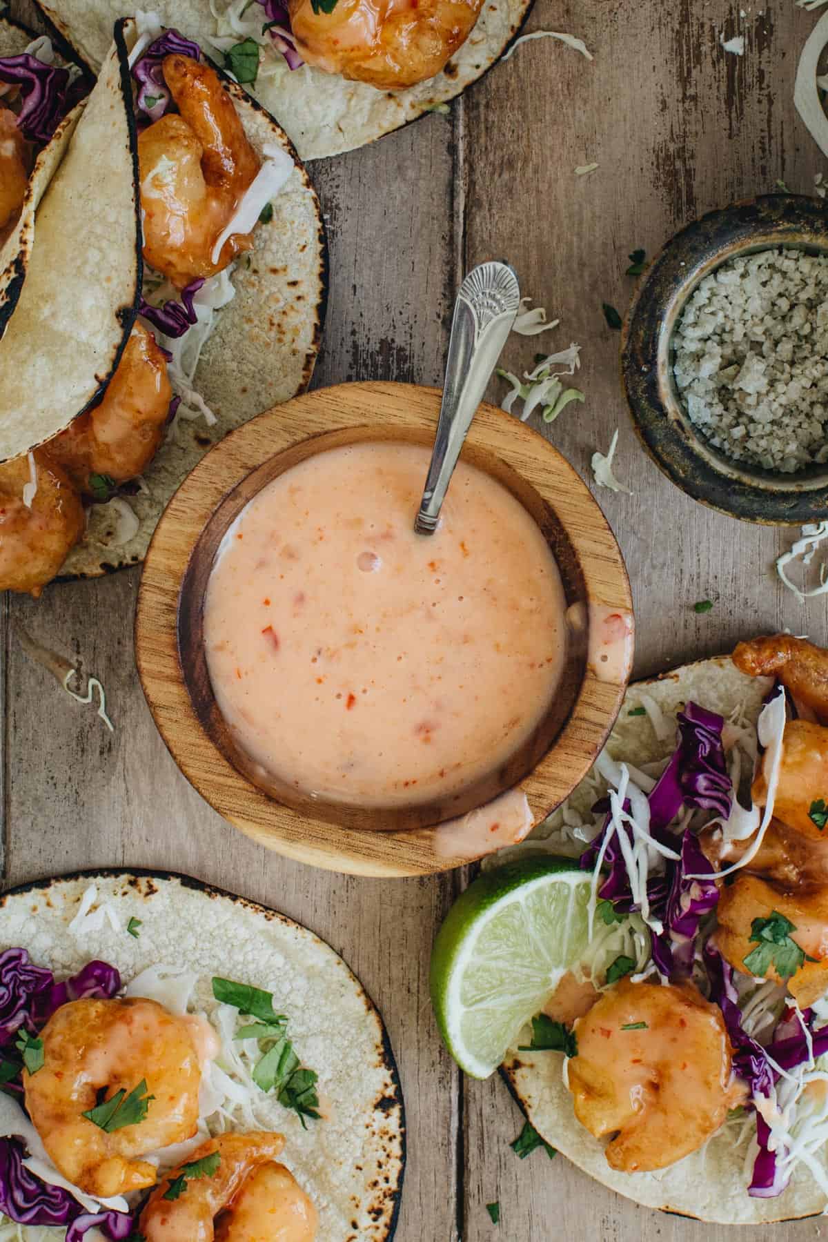 Bang bang sauce in a wooden bowl with a silver spoon.