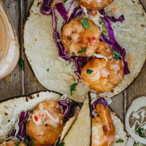 Bang bang shrimp taco with slaw and sauce.